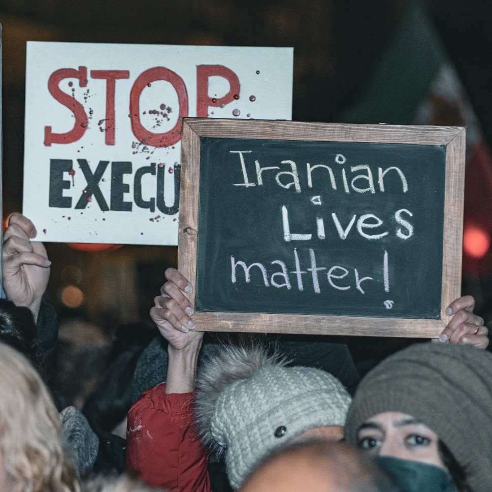 Photograph by Babak Dalivand. Iranian protesters in Austria hold signs that say 'Iranian Lives Matter' and 'Stop Executions.'
